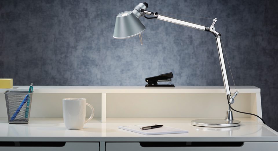 Artemide Tolomeo Mini aus Aluminium im Ambiente auf einem Schreibtisch mit Tacker Tasse und Büroutensilien